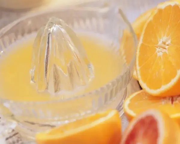 Exprimiendo naranjas en un vaso. ¡No te preocupes, la naranja engorda solo si te la comes entera!