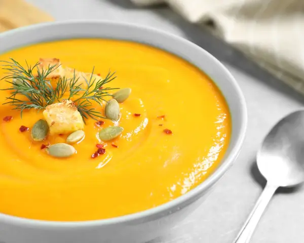 Crema de calabaza y jengibre, decorada con semillas de calabaza, picatostes y eneldo.