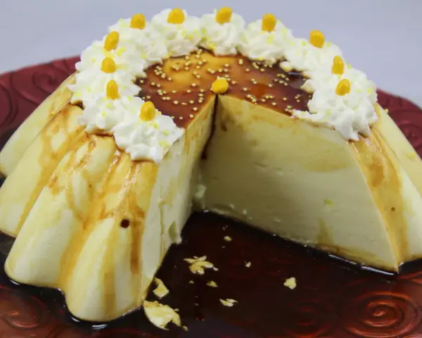 Delicioso flan de limón con caramelo, crema batida y decoraciones amarillas.