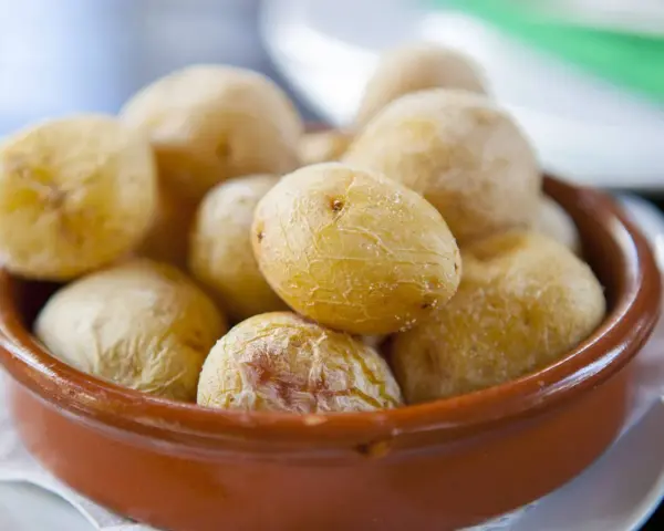 Papas arrugadas en cuenco de barro, un ejemplo del valor nutricional patata, con su piel salada y arrugada.