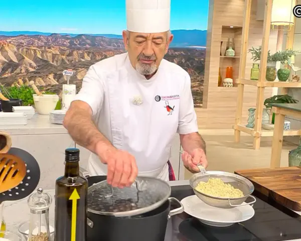 Chef muestra cómo cocinar quinoa, drenando el grano cocido en un colador.