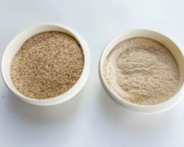Dos recipientes blancos con psyllium: uno con cáscaras y otro en polvo. Descubre qué es el psyllium.