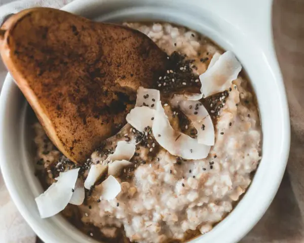 Un delicioso porridge que es avena cremosa con pera, coco rallado y semillas de chía.