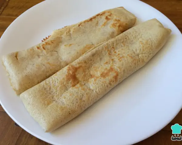 Dos crepes de avena enrollados en un plato blanco, listos para disfrutar.