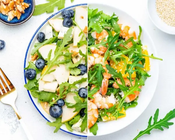 Dos ensaladas de rucula: una con pera, arándanos y nueces; la otra con gambas y naranja.