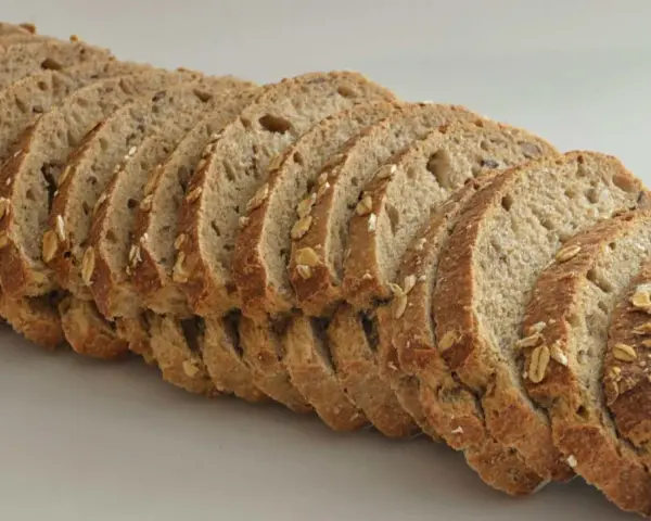 Rebanadas de pan de espelta con avena y semillas, listas para un desayuno saludable.
