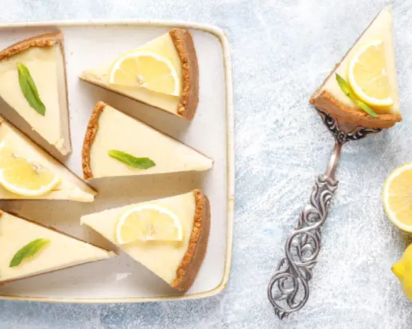 Porciones de pay de limón, decoradas con rodajas de limón y menta. ¡Perfectas para tu próxima receta de pay de limón!