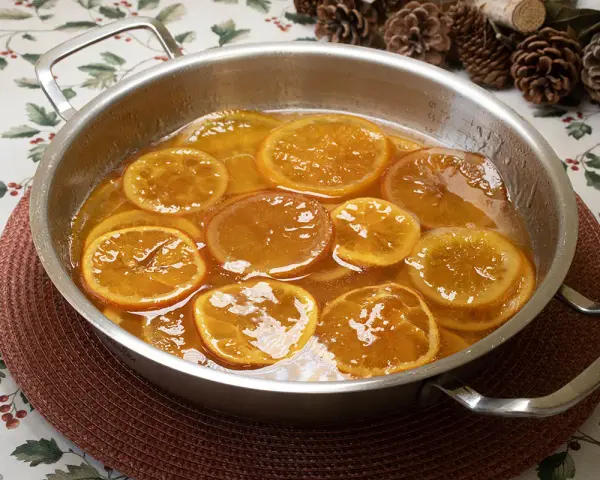 Rodajas de naranjas naturales confitadas en almíbar, un delicioso postre listo para disfrutar.