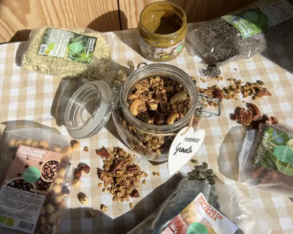 Ingredientes para una deliciosa receta de granola casera: avellanas tostadas, semillas de cáñamo, chía, calabaza, nuez pecan y crema de pistacho.