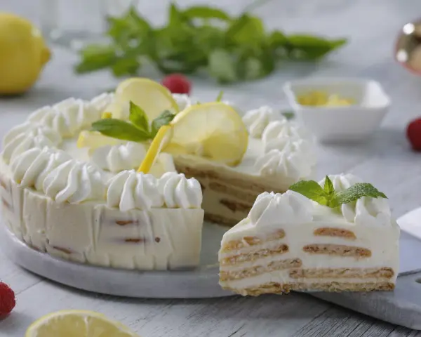La mejor tarta de limón con leche condensada, decorada con crema batida, rodajas de limón y menta. ¡Un postre refrescante y delicioso!