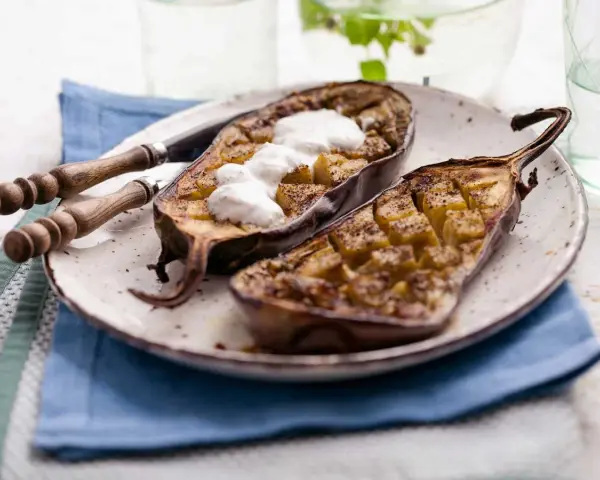 Berenjenas al microondas, cortadas por la mitad y rellenas, con una cucharada de yogur encima.