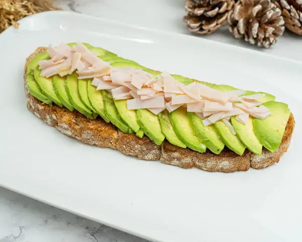 Tosta de aguacate con pavo desmenuzado, una opción saludable y deliciosa.