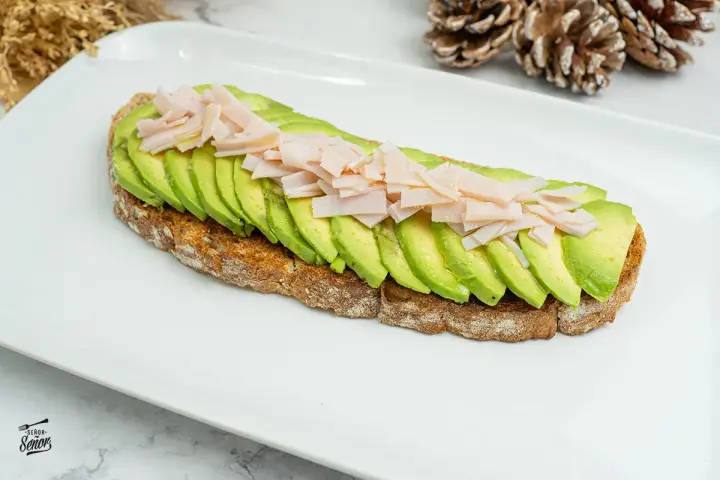 Tosta de aguacate con pavo desmenuzado, una opción saludable y deliciosa.