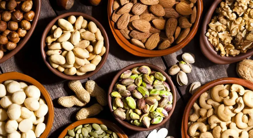 Variedad de frutos secos en cuencos: almendras, nueces, pistachos, anacardos, cacahuetes, avellanas y semillas de calabaza. ¡Perfectos para activar frutos secos!