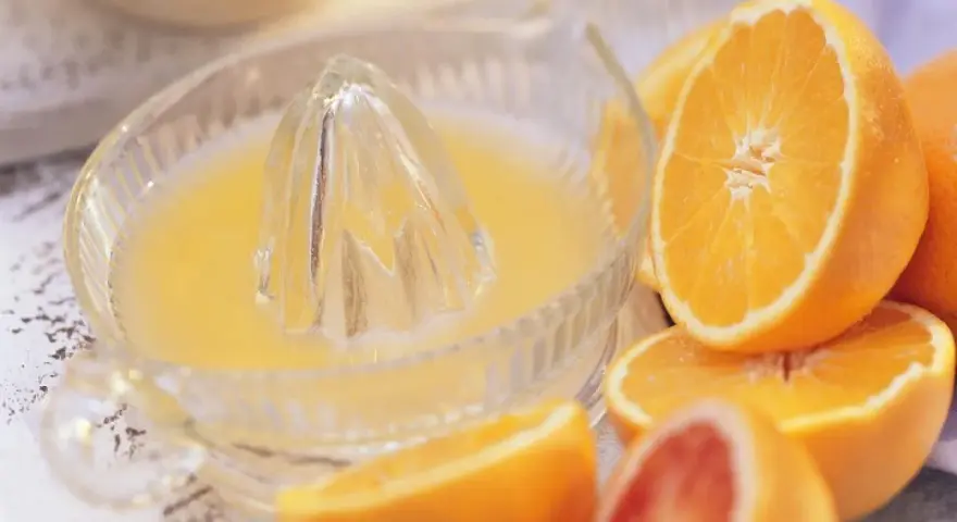 Exprimiendo naranjas en un vaso. ¡No te preocupes, la naranja engorda solo si te la comes entera!