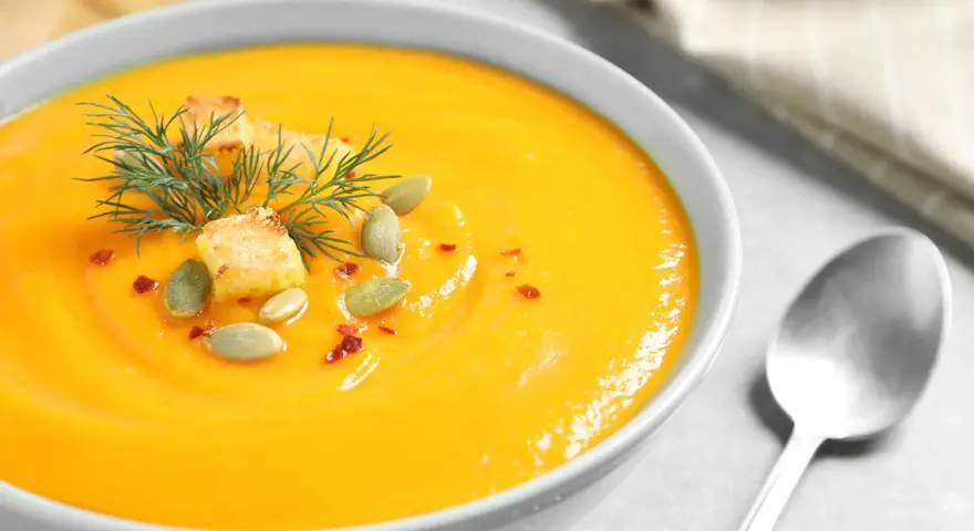 Crema de calabaza y jengibre, decorada con semillas de calabaza, picatostes y eneldo.
