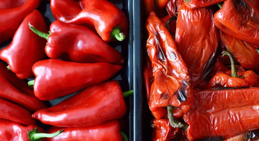 Dos recipientes llenos de pimientos rojos, unos frescos y brillantes, otros pimientos asados con la piel arrugada y un toque tostado.