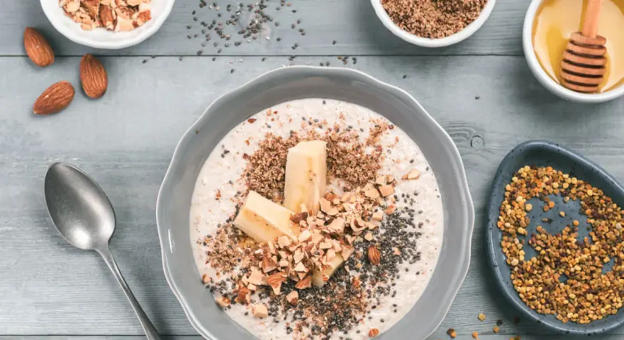 Un tazón de avena con plátano, almendras picadas, semillas de chía y miel. ¡Así es que es la avena, un desayuno nutritivo!
