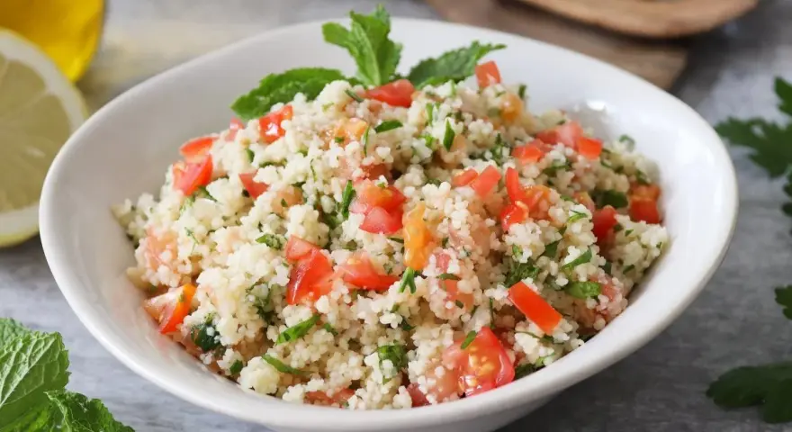 Delicioso tabule receta, con cuscús, tomate fresco, perejil y menta, listo para servir.