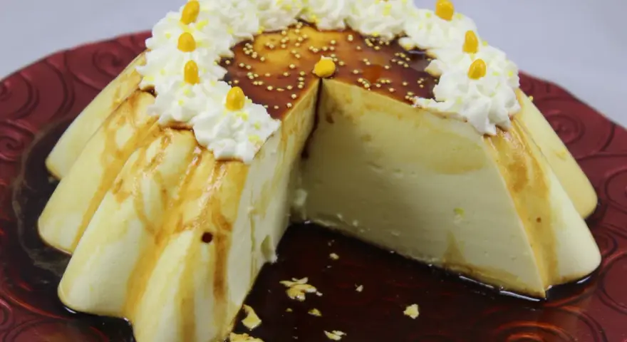 Delicioso flan de limón con caramelo, crema batida y decoraciones amarillas.