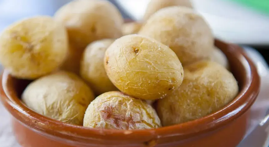 Papas arrugadas en cuenco de barro, un ejemplo del valor nutricional patata, con su piel salada y arrugada.