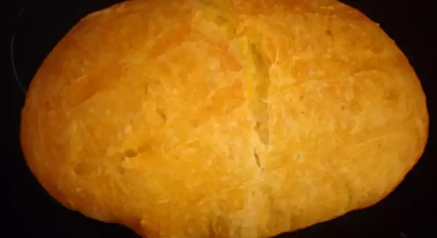 Pan de boniato dorado y esponjoso, con una corteza ligeramente agrietada, listo para disfrutar.