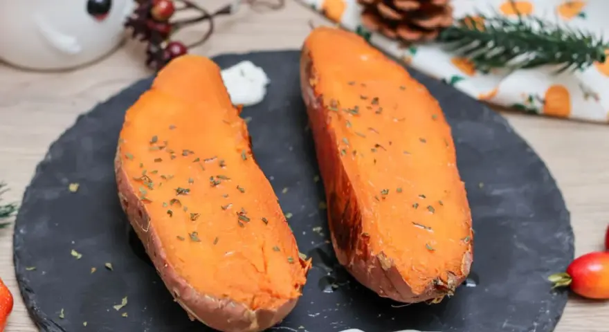 Dos mitades de boniato al horno, tiernas y doradas, con hierbas picadas y un toque de crema. ¡Un placer sencillo!