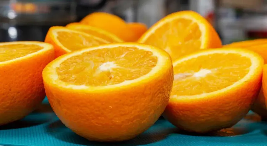 Naranjas cortadas por la mitad, jugosas y vibrantes. Aunque se dice que la naranja estriñe, su frescura invita a disfrutarla.