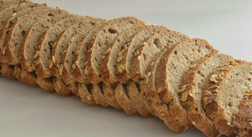Rebanadas de pan de espelta con avena y semillas, listas para un desayuno saludable.