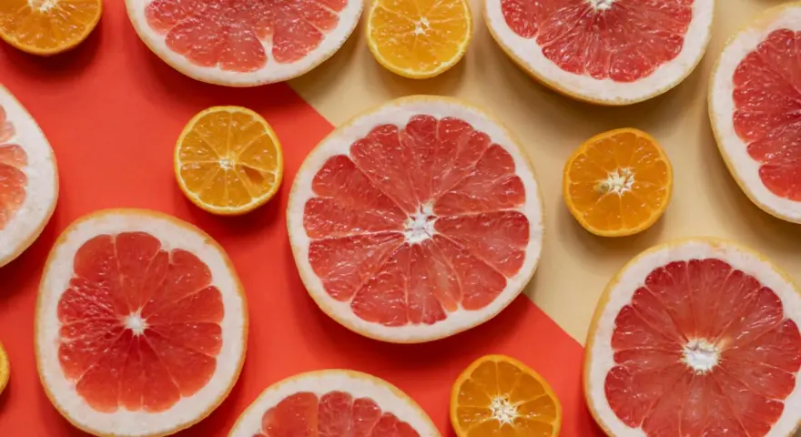 Pomelos y mandarinas cortados por la mitad, listos para disfrutar de los beneficios del pomelo en ayunas.
