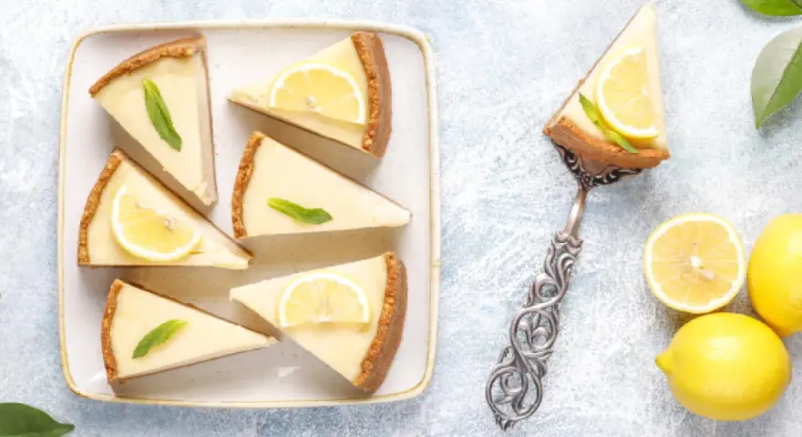 Porciones de pay de limón, decoradas con rodajas de limón y menta. ¡Perfectas para tu próxima receta de pay de limón!