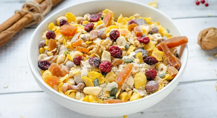 Un tazón lleno de muesli casero, con frutos secos, cerezas, albaricoques y semillas.