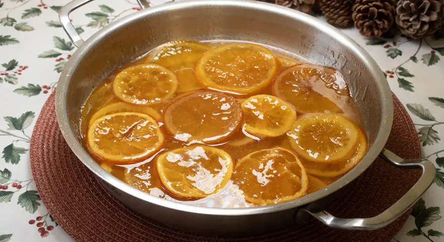 Rodajas de naranjas naturales confitadas en almíbar, un delicioso postre listo para disfrutar.