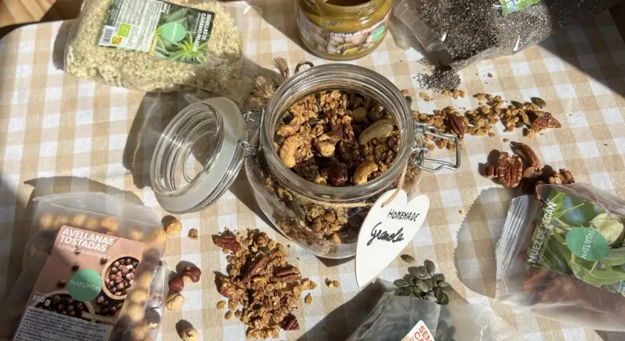 Ingredientes para una deliciosa receta de granola casera: avellanas tostadas, semillas de cáñamo, chía, calabaza, nuez pecan y crema de pistacho.
