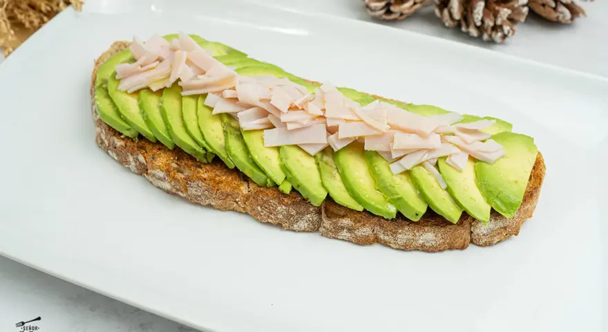 Tosta de aguacate con pavo desmenuzado, una opción saludable y deliciosa.