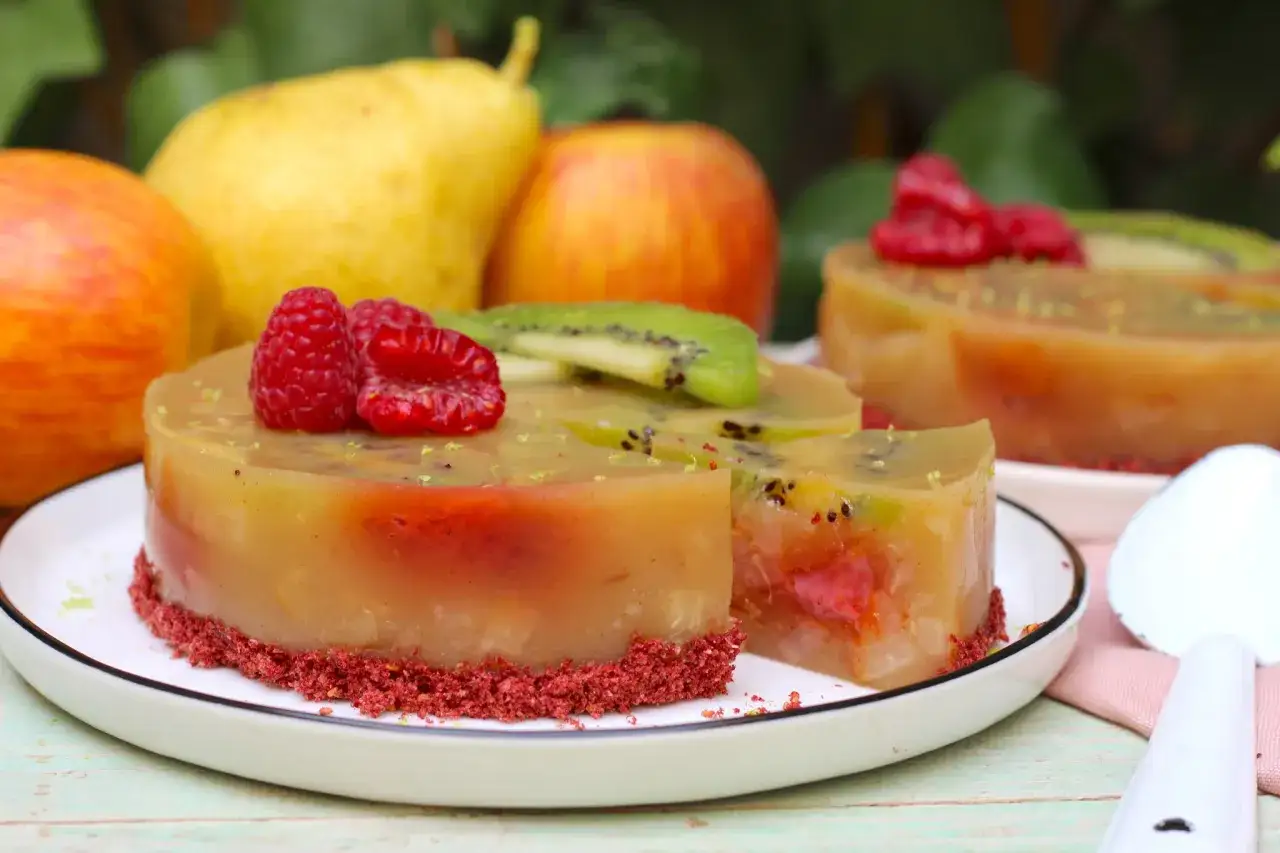 Postres con agar agar: tartas gelatinosas con kiwi, frambuesas y una base crujiente. Frutas frescas de fondo.