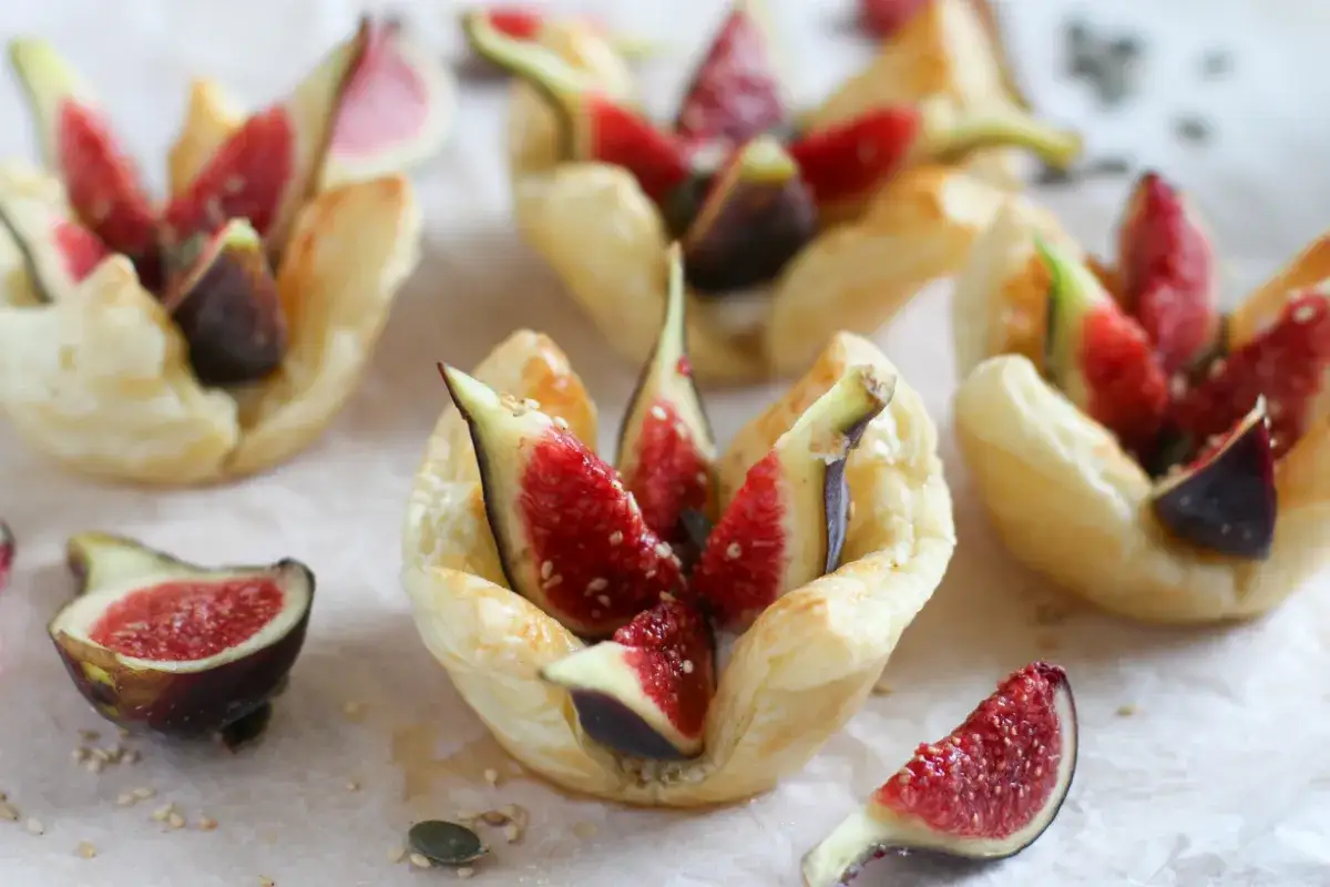 Deliciosos bocados de hojaldre con higos frescos y un toque de queso cremoso, espolvoreados con semillas.