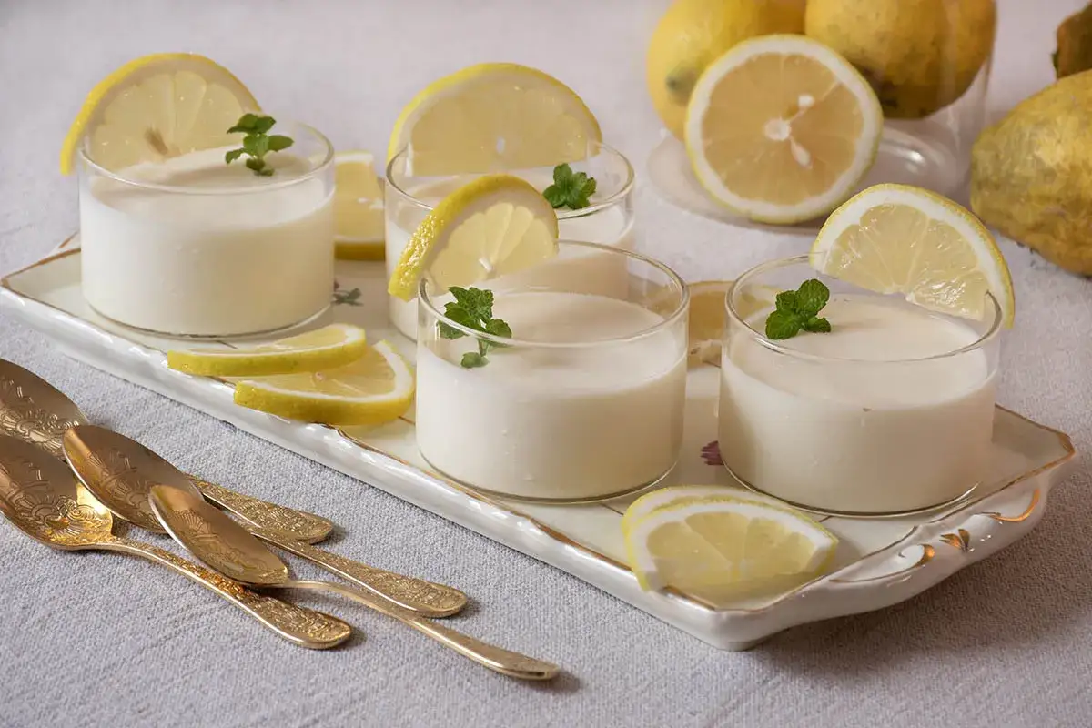 Deliciosa crema de limón para relleno, servida en vasitos con rodajas de limón y hojas de menta.