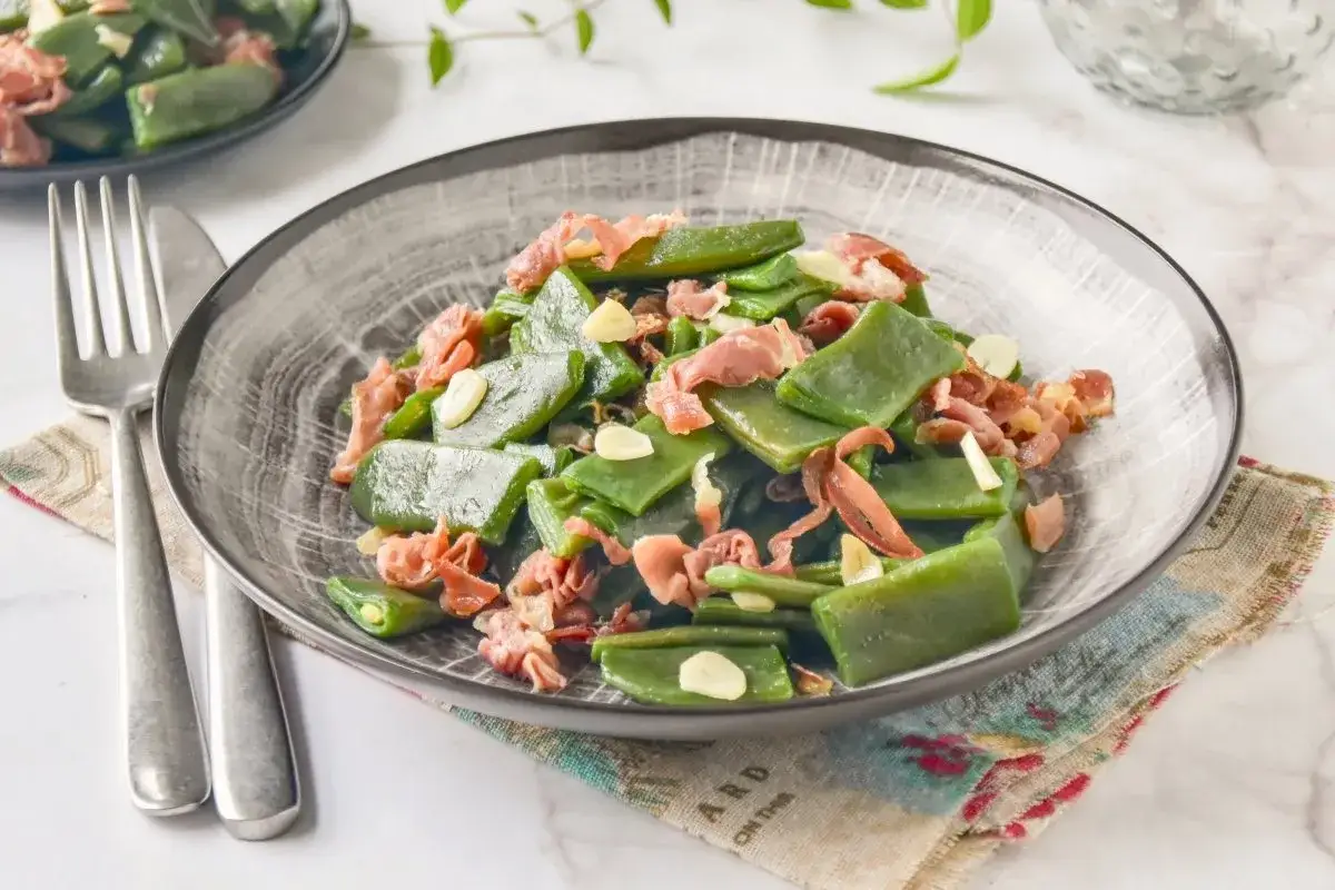 Plato de habichuelas salteadas con trocitos de jam&oacute;n y l&aacute;minas de ajo. Un plato sencillo y sabroso.