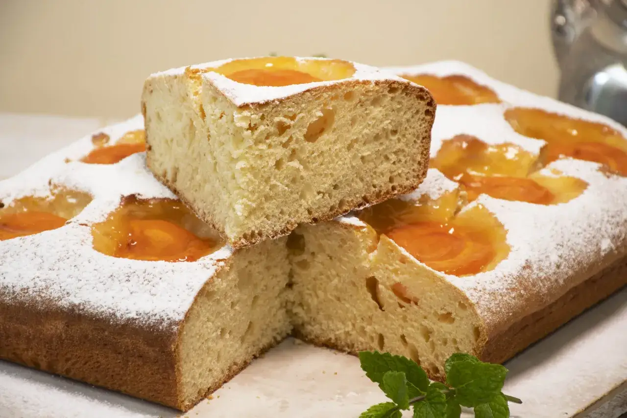 Deliciosa coca de albaricoque, cubierta de az&uacute;car glas y decorada con hojas de menta.