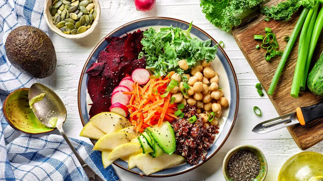 Un festín de colores y nutrientes: remolacha, kale, garbanzos, zanahoria, pepino, manzana y quinoa. Una deliciosa y dieta vegetariana equilibrada para disfrutar.