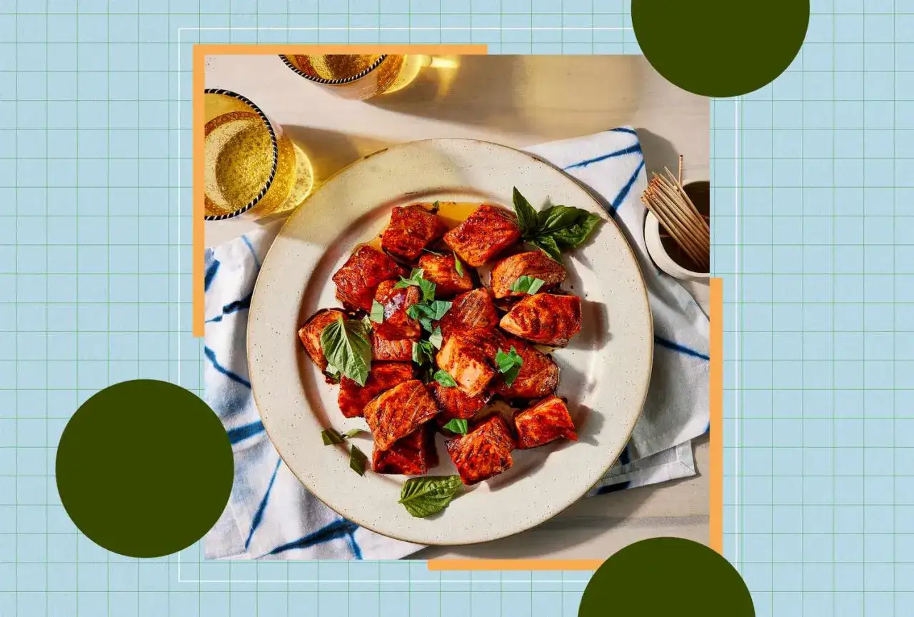 Sabrosos trozos de salmón a la parrilla, perfectos para una dieta antiinflamatoria, adornados con albahaca fresca.