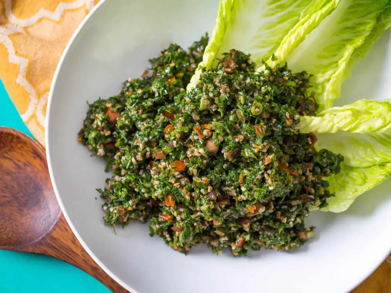 Delicioso tabule receta, una ensalada fresca de perejil, tomate y bulgur, servida con hojas de lechuga crujientes.
