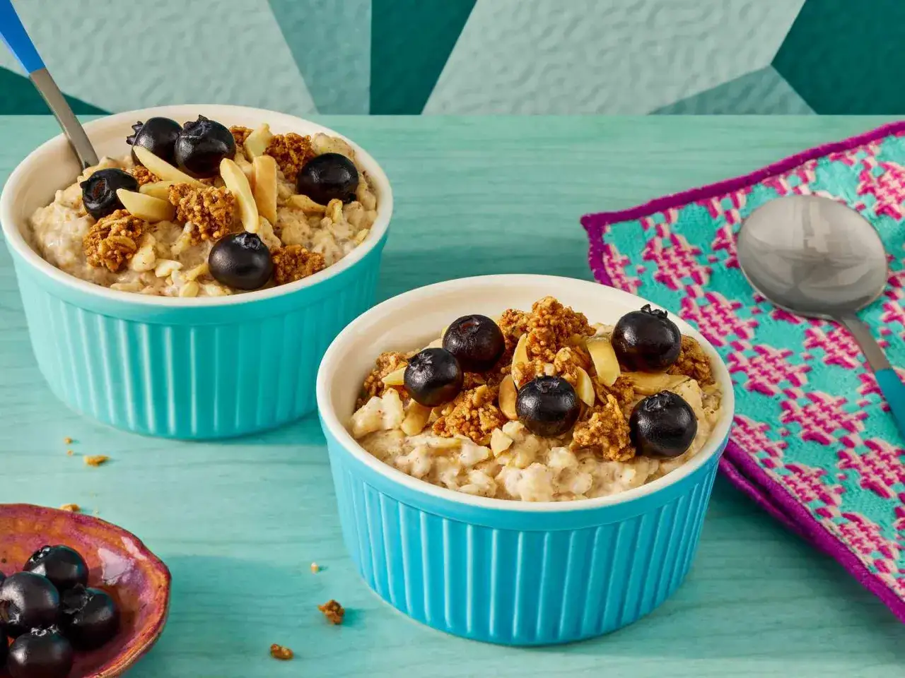 Dos tazones de avena cremosa con ar&aacute;ndanos y almendras. La avena es un cereal nutritivo, perfecto para empezar el d&iacute;a.