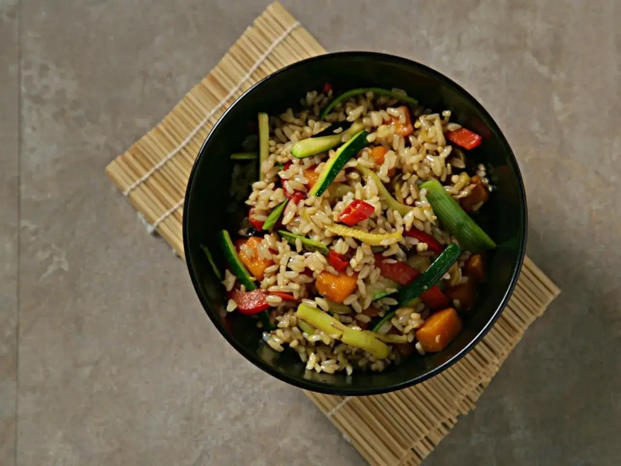 Un taz&oacute;n de arroz integral con verduras salteadas, calabac&iacute;n, pimientos y zanahoria.