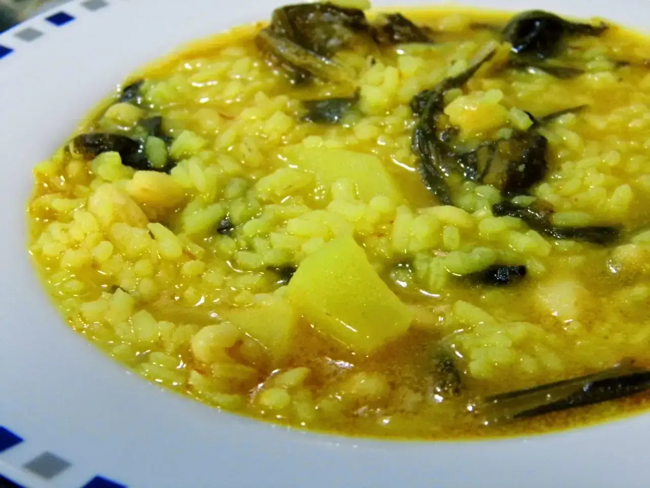 Arroz caldoso con acelgas, patatas y trozos de pescado. Un plato reconfortante y lleno de sabor.