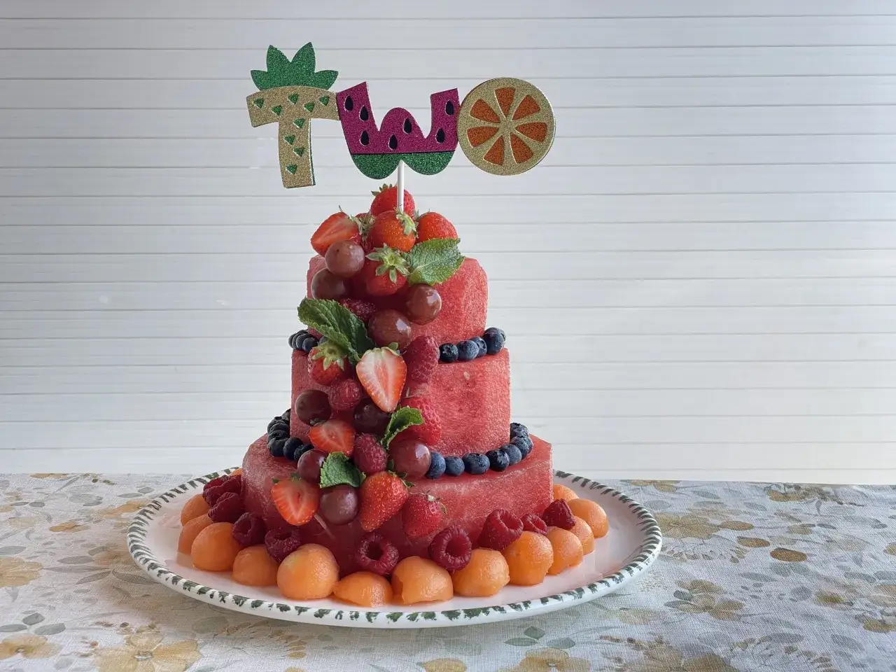 Pastel de dos pisos hecho de sand&iacute;a, decorado con fresas, ar&aacute;ndanos, frambuesas y uvas. &iexcl;Un fest&iacute;n de tartas de frutas!