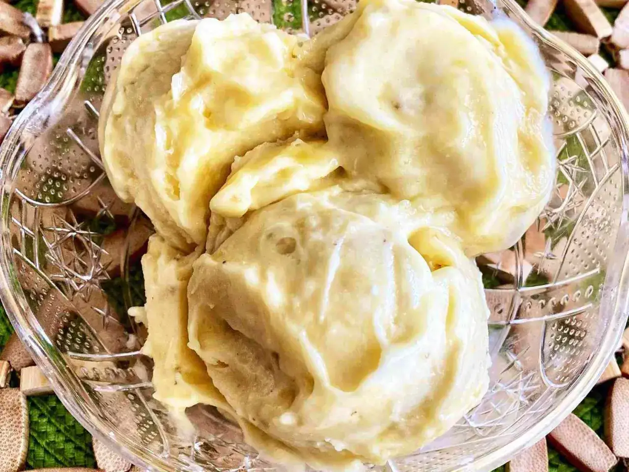 Delicioso helado de platano casero, cremoso y refrescante, servido en un cuenco de cristal.