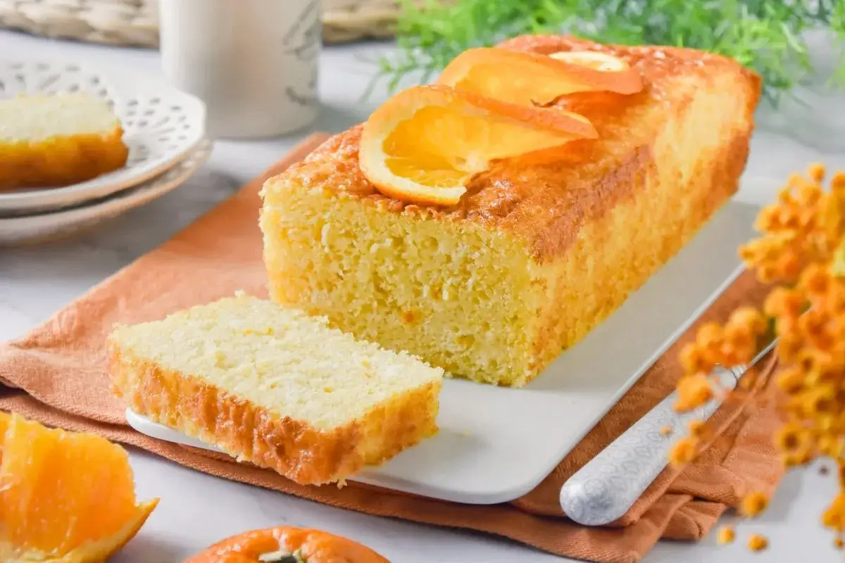 Bizcocho de naranja esponjoso, perfecto para aprender c&oacute;mo hacer un bizcocho de naranja casero. Decorado con rodajas de naranja fresca.