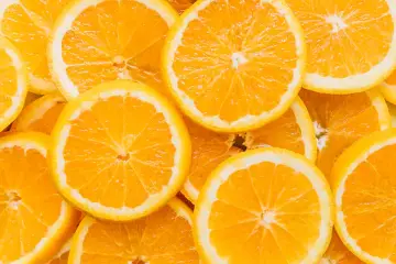 Rodajas de naranja vibrantes, llenas de vitamina C, dispuestas en un patrón apetitoso.